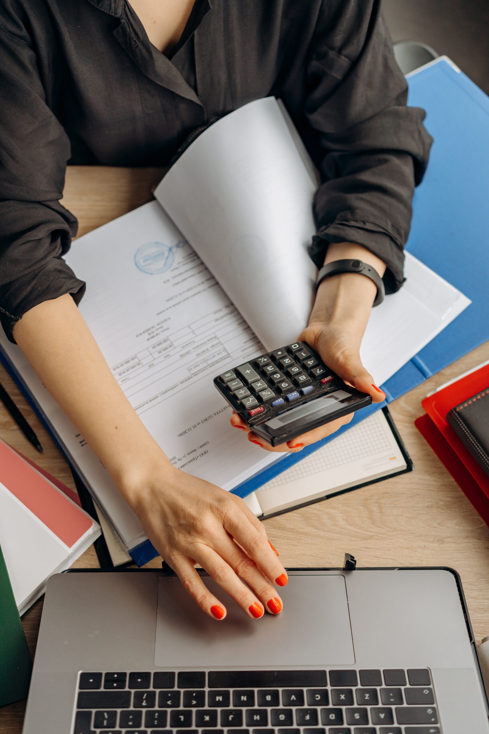 woman sat with calculator and laptop